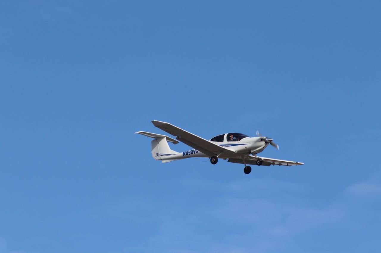 A small airplane soaring smoothly in a bright blue sky, showcasing aviation simplicity and freedom.
